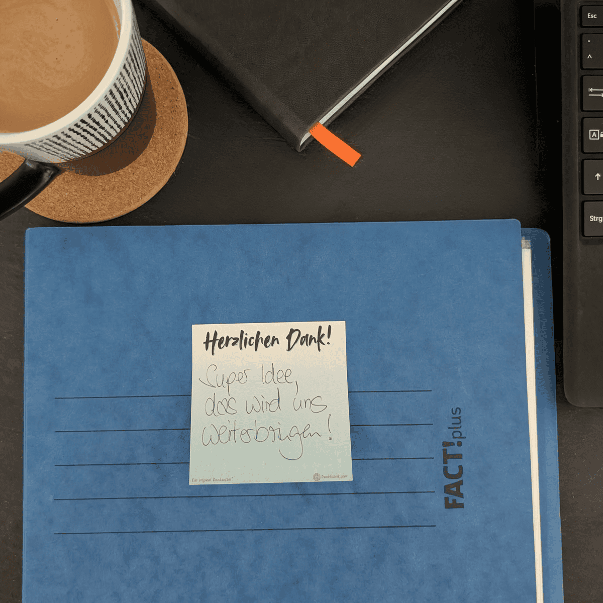 Kleiner beschriebener Dankzettel auf einer Akte aus hochwertigem Papier für Teams, Kollegen und Büros um Wertschätzung auszudrücken.